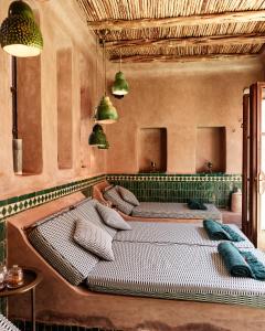 two beds in a room with green tiles at Le Jardin des Douars in Ghazoua