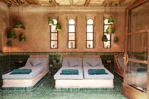 two beds in a room with two windows at Le Jardin des Douars in Ghazoua +20 photos