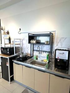 a kitchen with a sink and a microwave at Urban Emerald Seaview 6Pax 3Queen 3Room 2Bath 2Carpark with Infinity Pool in Jelutong