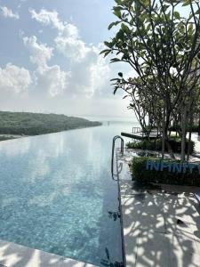 a swimming pool with a view of a body of water at Urban Emerald Seaview 6Pax 3Queen 3Room 2Bath 2Carpark with Infinity Pool in Jelutong