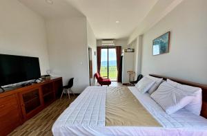 a bedroom with a bed and a flat screen tv at Light House Khao Yai in Ban Sap Noi