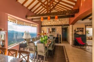 a dining room with a table and chairs and a large window at Oceania & Panorama Villas in Peyia