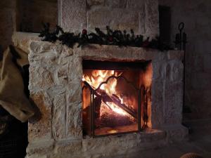 a stone fireplace with a fire in it at Milura Home - con vasca idromassaggi in Locorotondo +59 photos