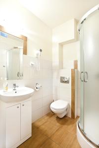 Un baño blanco con inodoro y lavabo. en Absolwent, en Duszniki-Zdrój