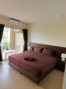 a bedroom with a large bed with a red blanket at Baan Thawin in Patong Beach