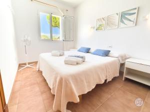 a bedroom with a large bed with towels on it at Apartamentos Annabel's II in Cala Galdana