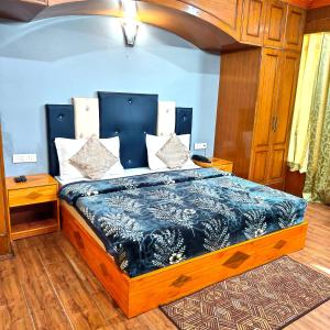 Un dormitorio con una cama con un edredón azul. en Melody Orchard Cottage, en Jagatsukh