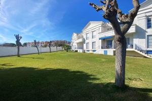a tree in a yard in front of a building at Apartamento Jara, playa, piscina, AC, Wi-Fi in Sanlúcar de Barrameda
