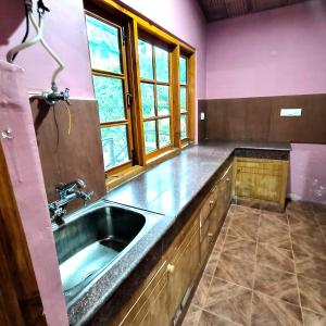 una cocina con fregadero y ventana en Melody Orchard Cottage, en Jagatsukh 32 fotos más