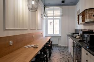 a kitchen with a long counter with stools in it at Stara Drukarnia Aparthotel in Koszalin