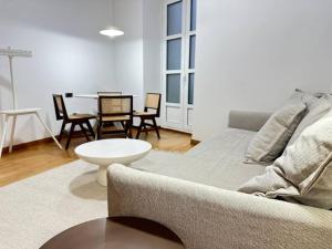 a living room with a couch and a table and chairs at YBH Puerta del Sol 11 in Vigo