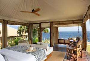 a bedroom with a bed and a view of the ocean at ARNA Suites and Ocean Lounge in Nusa Lembongan +32 photos