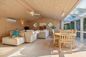 un soggiorno con un divano, un tavolo e delle sedie di Lovely Holiday Home By Beach And Nature At Lyngså a Sæby