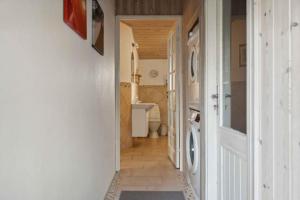 un corridoio che conduce a un bagno con lavatrice di Holiday Dream In Lyngså Sauna, Spa And Beach a Sæby Altre 19 foto