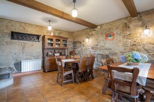 a dining room with stone walls and a table and chairs at Casa Rural Magina in Fornelos de Montes