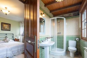 a bathroom with a bed and a sink and a shower at Casa Rural Magina in Fornelos de Montes +34 photos