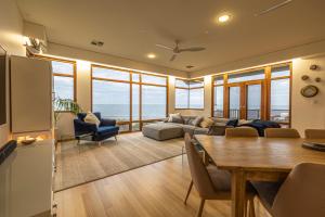 a living room with a table and a dining room at Seascape At Tennyson Beach in Grange