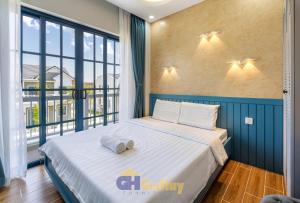 Un dormitorio con una cama y una ventana grande. en Biệt thự nghỉ dưỡng Phan Thiết, en Phan Thiet