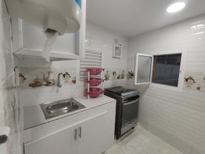 a small kitchen with a sink and a stove at ريف سوق نزوى in Nizwa