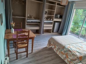 a room with a table and a bed and a bedroom at Une escale gourmande in Eyzerac