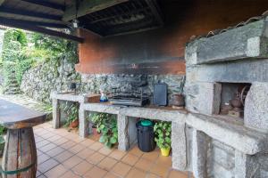 an outdoor kitchen with a stone wall at Casa Rural Magina in Fornelos de Montes