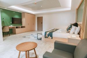 a hotel room with a bed and a couch and a table at Diane Residences in Mabolo