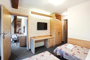 Una habitación de hotel con escritorio y televisión. en Absolwent, en Duszniki-Zdrój