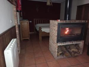 a living room with a brick fireplace in a room at La Casita Roja Del Arcoíris in Riópar +1 photo