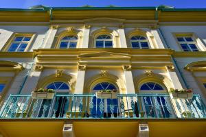 a building with a balcony with flowers on it at Residence Le théâtre in Mariánské Lázně +79 photos