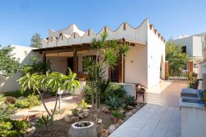 una casa con cortile alberato e piante di Di Mari e d'Amuri Casa Vacanza a Tonnara di Bonagia