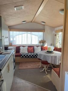 a living room with a couch and a table at Ecco Lodge Caravan in Leysdown-on-Sea