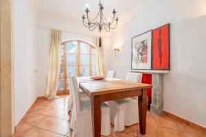 Un comedor con mesa y sillas de madera. en Rialza, en Petra