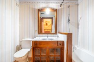 Un baño con inodoro, lavabo y espejo. en Rialza, en Petra