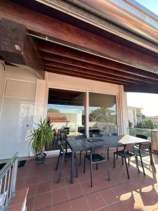 a patio with a table and chairs on a deck at Luxory Appartament in Bussolengo