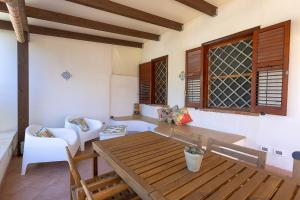 un soggiorno con tavolo e sedie in legno di Di Mari e d'Amuri Casa Vacanza a Tonnara di Bonagia Altre 41 foto