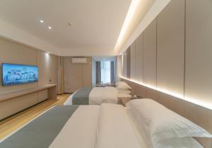 a hotel room with two beds and a flat screen tv at Lucky Praised Scenery Hotel in Zhangjiajie +53 photos