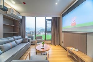 a living room with a couch and a projection screen at Lucky Praised Scenery Hotel in Zhangjiajie
