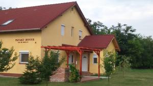 una pequeña casa amarilla con techo rojo en Pataki House, en Mórahalom