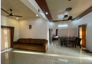 salon z kanapą i stołem w obiekcie Villa Montagna By Nutan Holidays w mieście Karjat