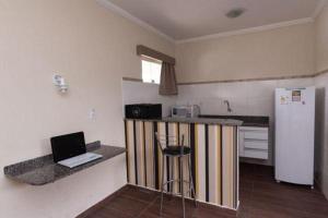 a kitchen with a laptop computer sitting on a counter at Colonial Flat Hotel in Itapetininga