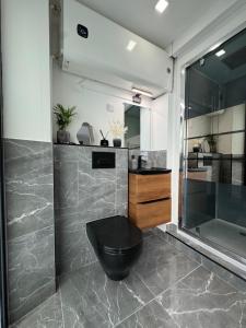 a bathroom with a black toilet and a sink at L’Eden Centre ville in Melun