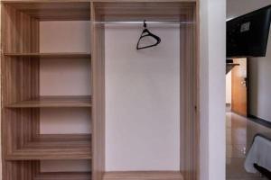 a wooden book shelf with a hanger in a room at Colonial Flat Hotel in Itapetininga