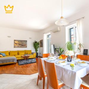 a living room with a table and a yellow couch at White House Luxury Suite in Split