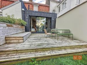 a wooden deck with a table and chairs on it at La Saumonerie - Charmante maison a 200m de la plage de Wimereux in Wimereux