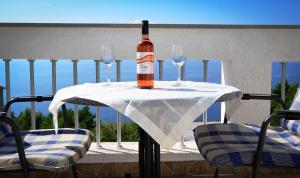 a bottle of wine sitting on a table with two glasses at Apartment Via in Brela