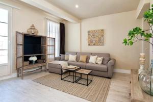 a living room with a couch and a tv at Penthouse Lorena in Granada