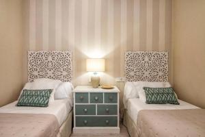 a bedroom with two twin beds and a night stand at Penthouse Lorena in Granada +10 photos