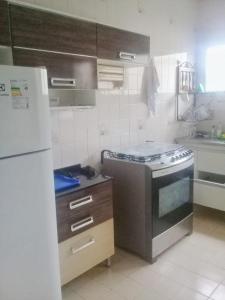 a kitchen with a stove and a refrigerator at Guarapari 3 quartos com suíte e garagem no Centro de Guarapari in Guarapari