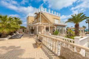 una casa con ringhiera bianca e palme di Fidalsa Prime Mediterranean Beachfront a Orihuela Costa