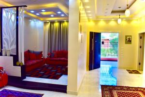 a living room with red couches and a balcony at Karma Kono in Abu Simbel